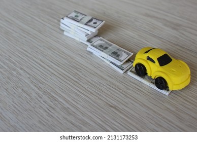 Selective Focus Image Of Toy Car And Stack Of Money. Car Depreciation, Value Concept.