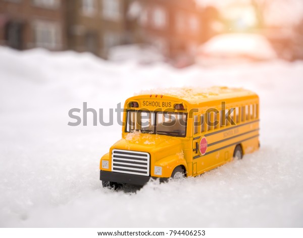 Selective focus Image of yellow school\
bus toy model on the snowing day. / with copy\
space