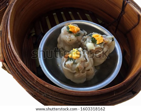Selective focus- Isolated minced pork Shumai Dim Sum, Steamed Chinese food served in small wooden basket container
