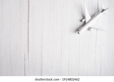 (Selective focus) Isolated white model aircraft on a blurred white background. Travel concept, flat lay with copy space. 