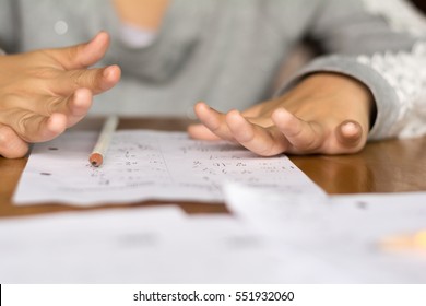 Selective Focus Kid Using Hands For Compute Homework Math On Wooden Table In Room,student Child Girl Counting By Fingers For Home Work, Calculate The Results On Paper , Education Concept