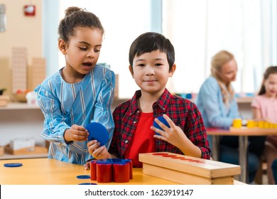 Selective focus of kids with educational game and teacher with child at background in montessori class - Powered by Shutterstock