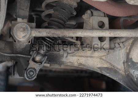 Selective focus at the leaking and broken left side shock absorber of the truck. Car repair or maintenance background. 