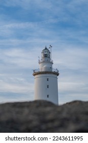 selective focus of a lighthouse, behind blurred sand dunes in the foreground - Shutterstock ID 2243611995