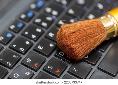 Selective Focus Of Makeup Brush On Laptop Keyboard Keys. Computer Cleaning Concept.