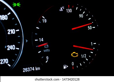 Selective Focus Of Malfunction Check Engine Warning Light On Car Dashboard. Side View Of Modern Car Instrument Panel With Odometer, Car Water Temperature, Car Voltmeter And Fuel Gauge.