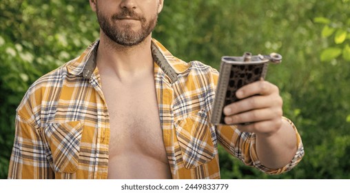 selective focus of man with bourbon hipflask outdoor. man with bourbon hipflask