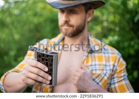 selective focus of man with bourbon hipflask outdoor, copy space. man with bourbon hipflask