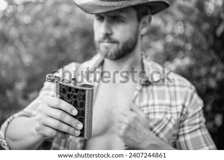 selective focus of man with bourbon hipflask outdoor, copy space. man with bourbon hipflask