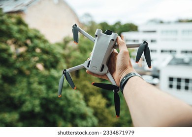 A selective focus of a man hand holding a small light drone outdoors