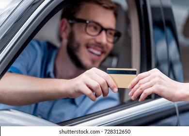 Selective Focus Of Man Paying With Credit Card While Driving Car