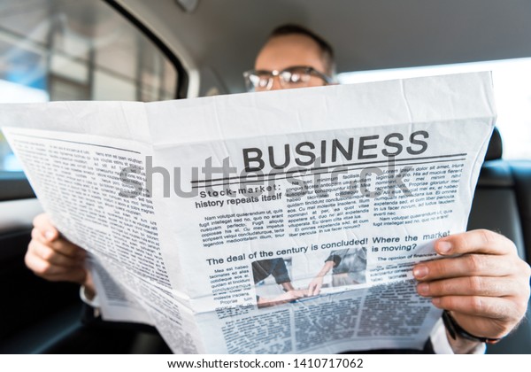 selective\
focus of man reading business newspaper in car\
