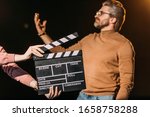 selective focus of mature actor performing role with clapboard in front