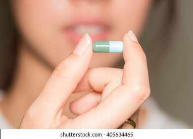 Selective Focus Medicine Pills Or Capsules In Hand, Palm Or Fingers. Drug Prescription For Treatment Medication. Woman, Young Female, Person Taking Vitamin, Painkiller, Antibiotic