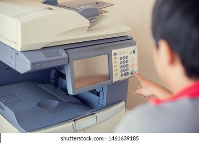 Selective focus to men press the button on panel of the copier and scanner. Business man using all in one machine, printer, scanner and copier. Working in office concept.