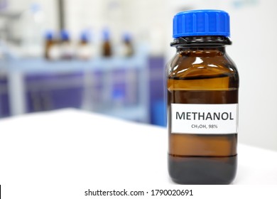 Selective focus of methanol solution in brown amber glass bottle inside a laboratory. Blurred background with copy space.