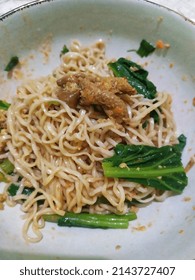Selective focus Mie Ayam, Indonesian Popular Street Food with Noodle, Chicken, and Green Vegetables with Delicious Broth. Look like noised. 