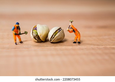 selective focus of miniature construction workers with pistachio nuts - Powered by Shutterstock