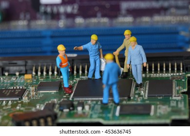 Selective focus of miniature engineer and worker discuss to fixed problem on chips in computer mainboard as business and industrial concept.