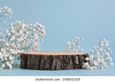 Selective focus. A minimalistic scene of a felled tree lies with flowers on a blue background. Catwalk for the presentation of products and cosmetics. A showcase with a stage for natural products. - Shutterstock ID 1930615319