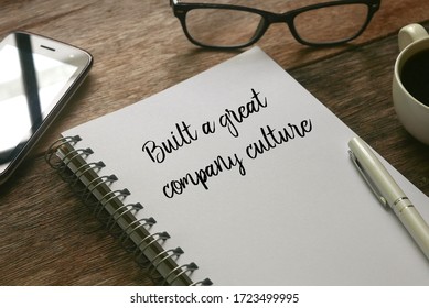 Selective Focus Of Mobile Phone,glasses,a Cup Of Coffee,pen And Notebook Written With ' Built A Great Company Culture ' On Wooden Background.