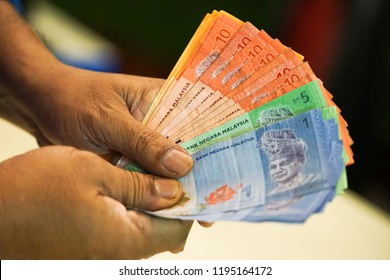 Selective focus at money with hand,showing Ringgit Malaysia. - Shutterstock ID 1195164172