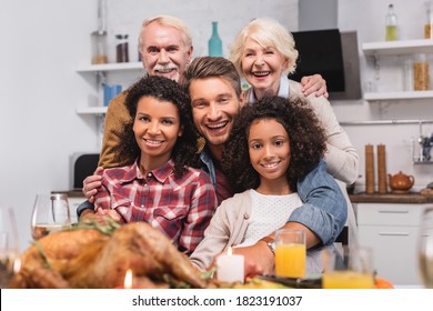 Selective Focus Of Multicultural Family Looking At Camera While Celebrating Thanksgiving