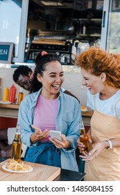 Selective Focus Of Multicultural Girls Laughing Near African American Man And Food Truck 