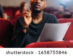 selective focus of multicultural young actor and actresses reading scripts in theater