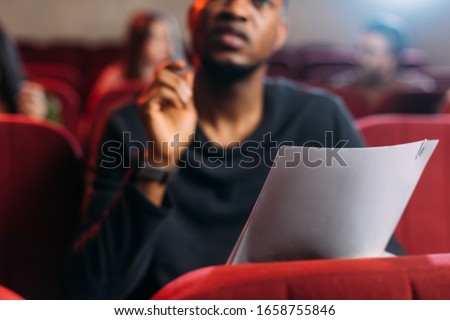 selective focus of multicultural young actor and actresses reading scripts in theater