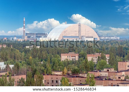 Selective focus, new safe confinement arch with blue sky at the Chernobyl nuclear power plant through the prospect of abandoned Pripyat. NSF is a new sarcophagus for safe deactivation work.