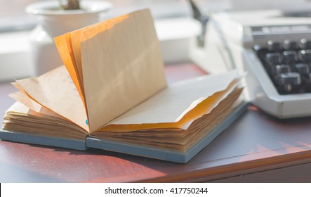 Selective focus note book paper with typewriter on wooden of old desk ,vintage tone