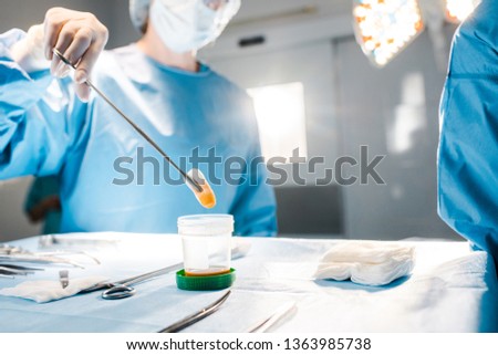 selective focus of nurse in uniform and medical cap holding tampon with medical equipment 