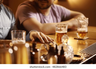 Selective Focus. Old Friends Meeting At Pub Over Beer. Two Partners Having Good Time At Bar, Celebrating Success After Making Profitable Deal, Sitting At Table With Glasses, Discussing Business Plans