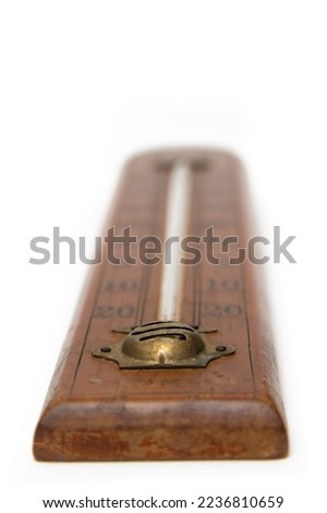 Selective focus of an old mercury thermometer, graduated in centigrade with wooden base on a white background, marking 10 degrees