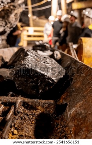 Selective focus on anthracite coal on a conveyer belt with defocused group in the Lackawanna Coal Mine Tour at McDade Park.