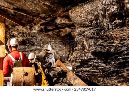 Selective focus on anthracite coal on a conveyer belt with defocused group in the Lackawanna Coal Mine Tour at McDade Park.