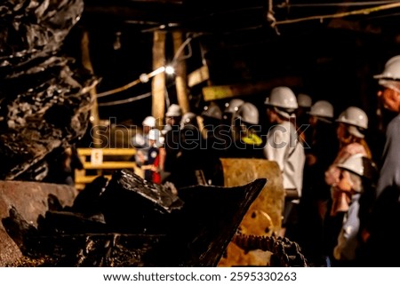 Selective focus on anthracite coal on a conveyer belt with defocused group in the Lackawanna Coal Mine Tour at McDade Park.
