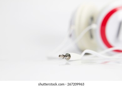 selective focus on audio plug of headphones on white background