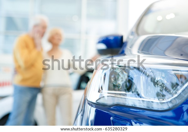 Selective focus on a car elderly married couple\
hugging choosing automobile to buy on the background copyspace\
purchase buying consumers clients lifestyle drive ownership travel\
vehicle transport