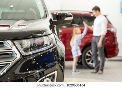 Selective Focus On A Car Little Girl High Fiving Her Father On The Background Family Buying New Automobile Consumerism Lifestyle Travel Bonding Happiness Vehicle Rental Service Concept Copyspace