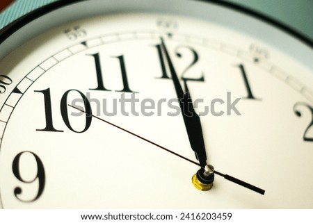 selective focus on a clock with white dial. 12 o'clock time