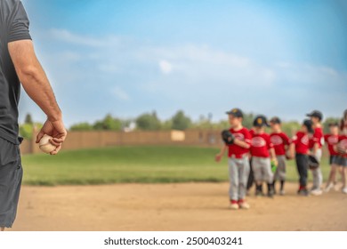 Selective focus on a coach getting ready to toss a ball to a child during practice  - Powered by Shutterstock