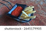 Selective focus on crispy fries and ketchup on the restaurant table.