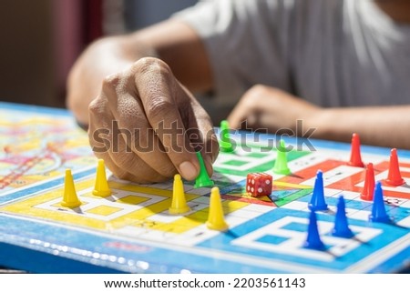 selective focus on a dice and human hand holding moves of ludo indoor game