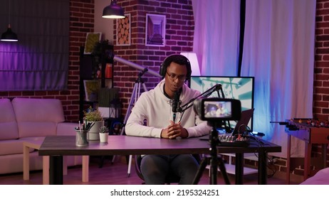 Selective focus on digital video camera screen recording african american influencer hosting podcast for vlog post. Content creator filming and streaming live internet show from home studio. - Shutterstock ID 2195324251