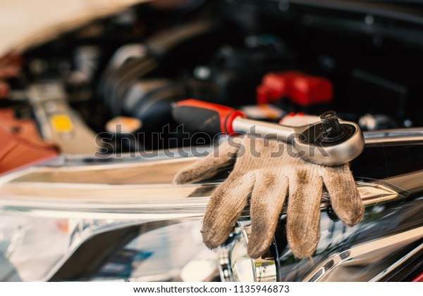 Selective focus on duty dirty glove\
with car engine with tools made with filter color\
effect
