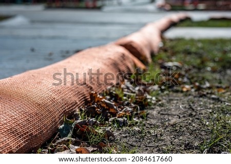 selective focus on filter sock around exposed dirt at a construction site to prevent stormwater erosion and runoff 
