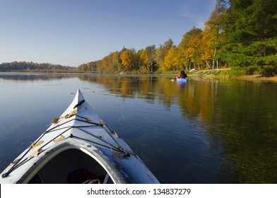 Selective focus on the foreground kayak on a tranquil autumn morning with another kayak in the distance - Powered by Shutterstock