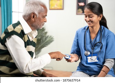 Selective Focus On Girl, Concept Of Home Health Visit Or Service - Doctor Or Nurse Checking Pulse Using Pulse Oximeter Of Sick Senior Man While Both Worn Face Mask